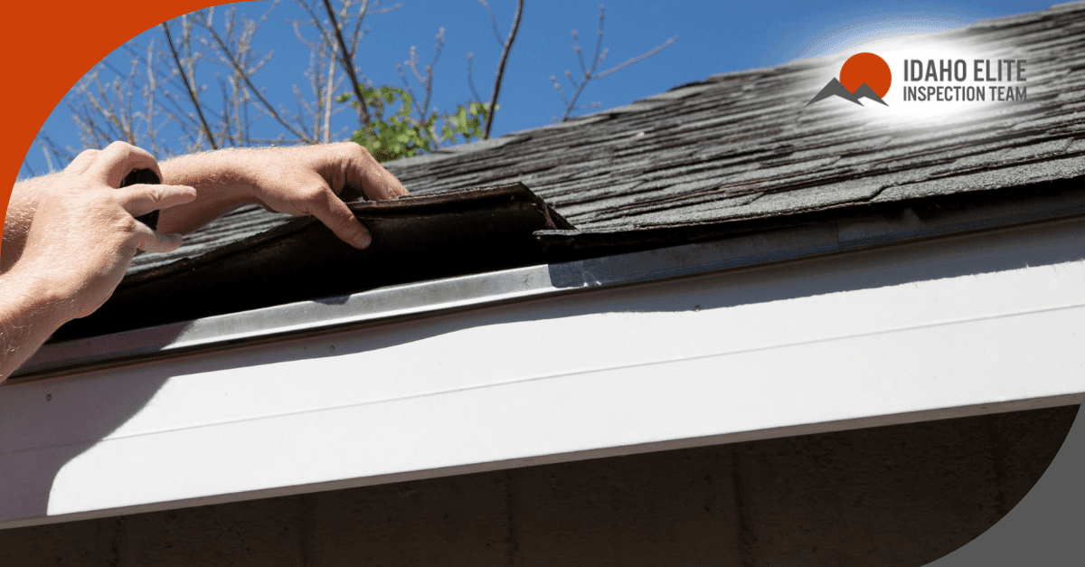 Inspector lifting roof shingles to check for hidden damage.