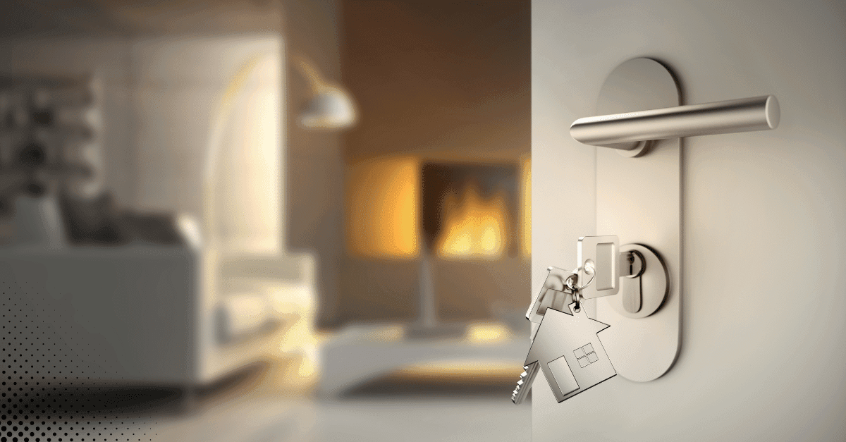 House-shaped keychain hanging from a key in a door lock.